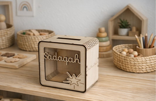 Tirelire en bois personnalisée au prénom Sadaqah avec gravure étoile et pièces de monnaie visibles à l'intérieur