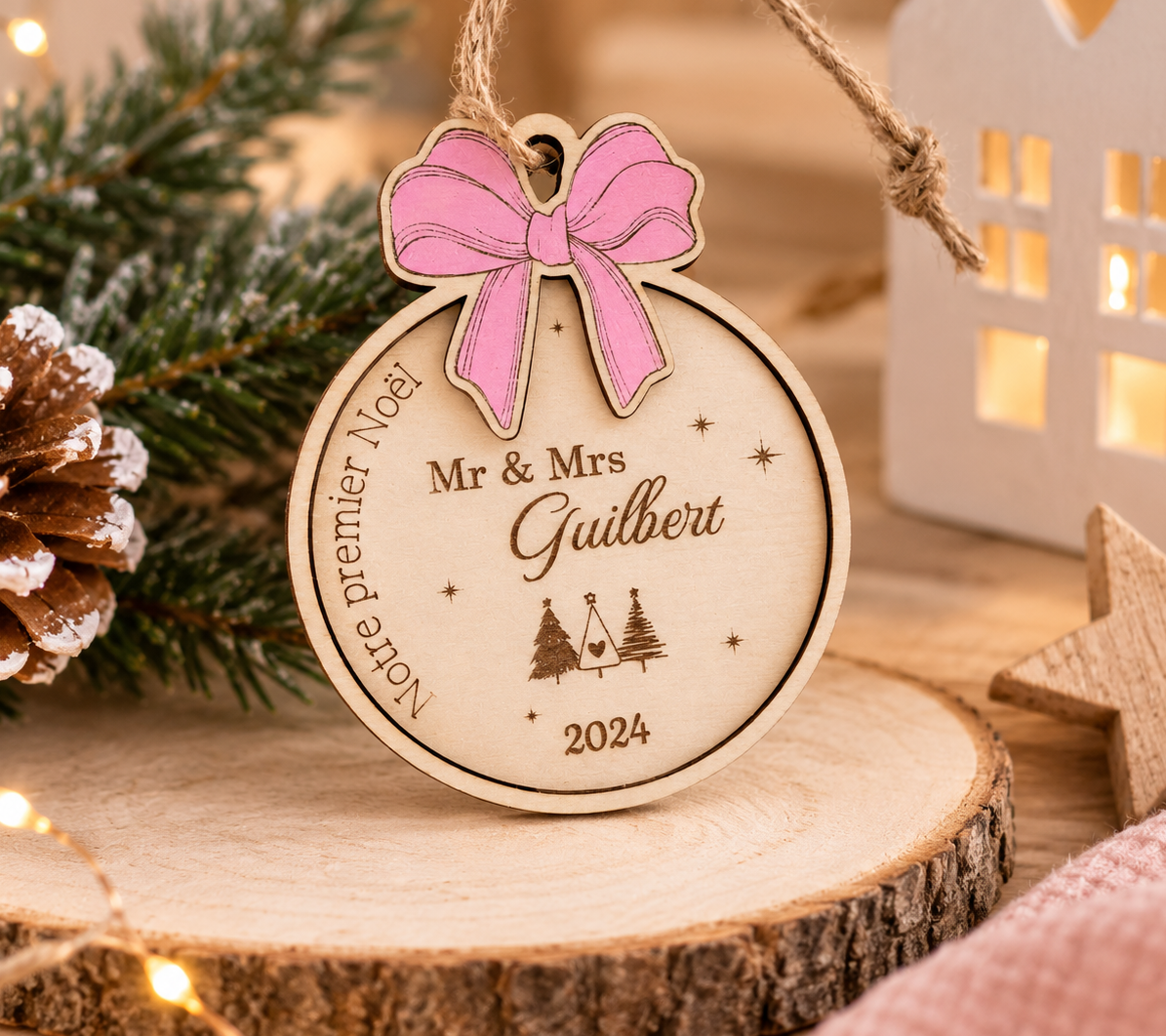 Boule de Noël en bois personnalisée « Notre premier Noël » avec Mr & Mrs, année, chalet et sapins gravés, nœud rose