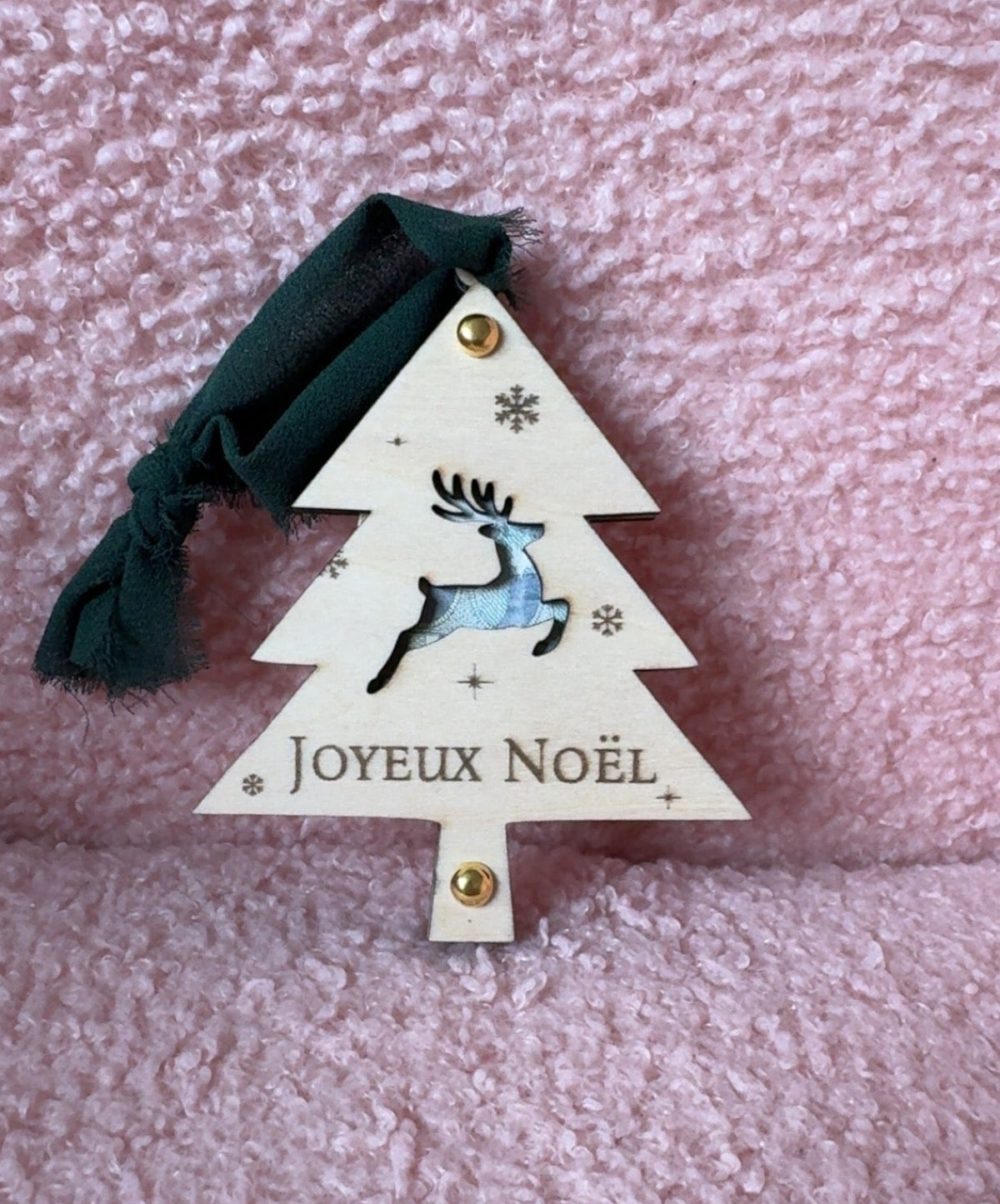 Sapin de Noël en bois « Joyeux Noël » avec renne bondissant découpé laissant voir un billet, flocons gravés et ruban vert